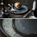 Split picture: the top shows the small platter with a scone and cutlery on it atop wooden table, the bottom shows a close-up of the details of the metal platters.