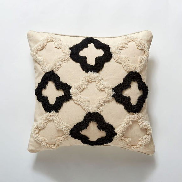 Cream pillow with three rows of three textured plus signs, alternating between black and cream.