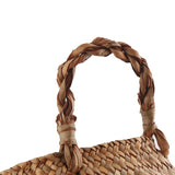 Close-up of the handle of the seagrass basket shows the detail and texture of the material.